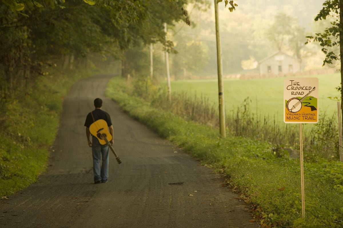 A musician carrying a guitar case along The Crooked Road in Southwest Virginia